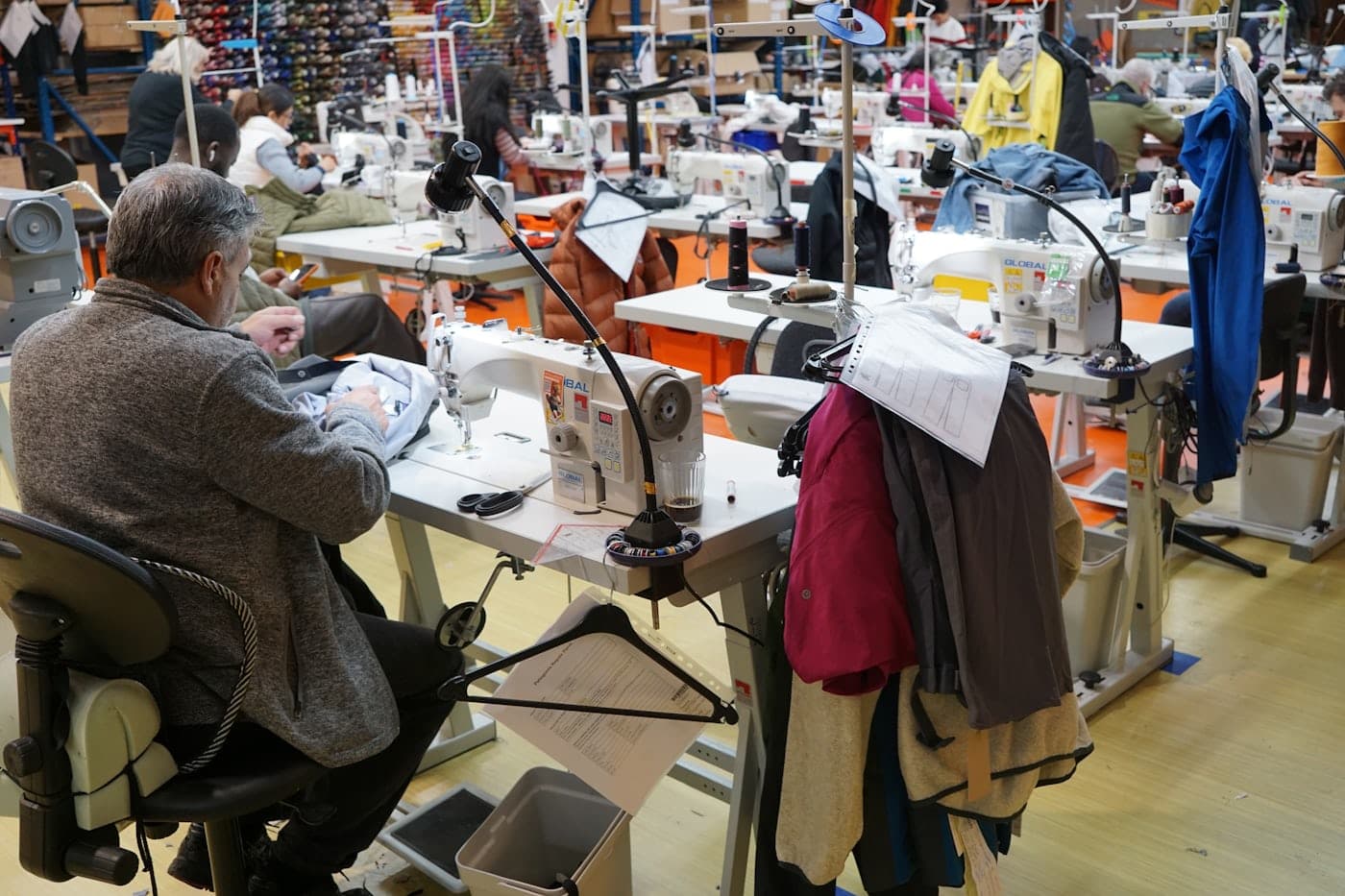 Operators at rows of sewing machines in a workshop